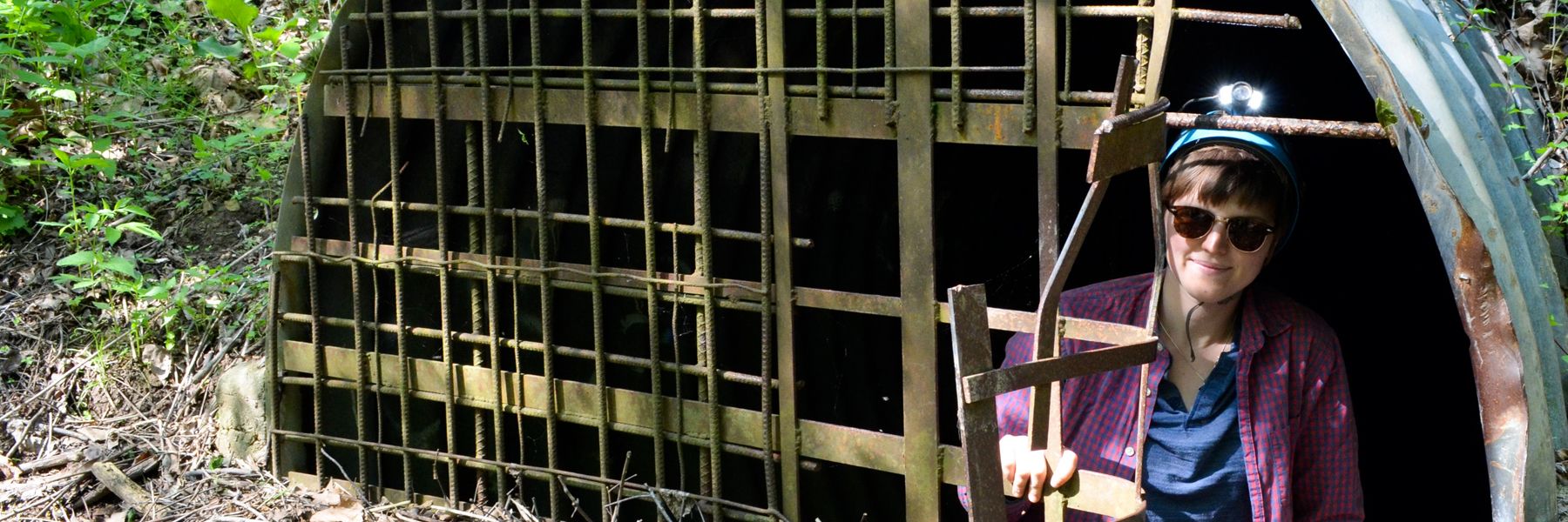 Student climbing underground to study bats.